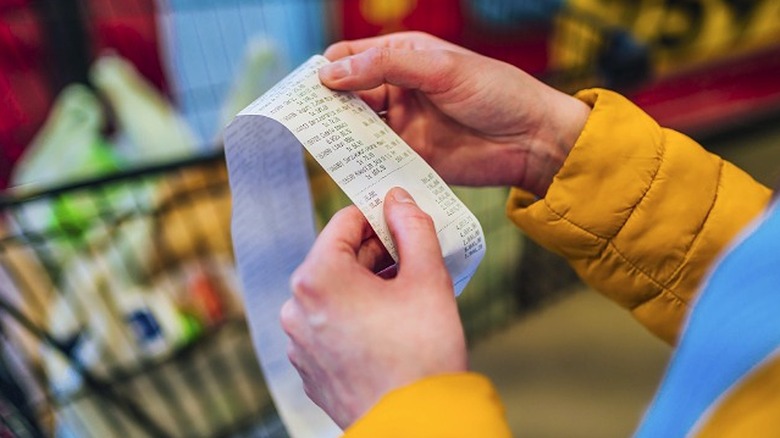 Hands holding receipt after checkout