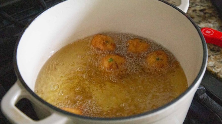 golden brown hush puppies frying in oil