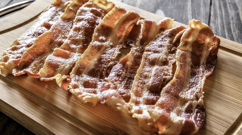 cooked bacon on wooden board