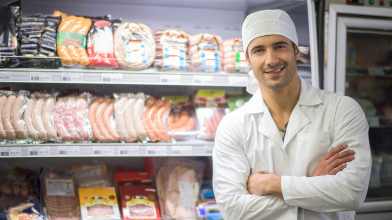 Man beside refrigerated meat counter