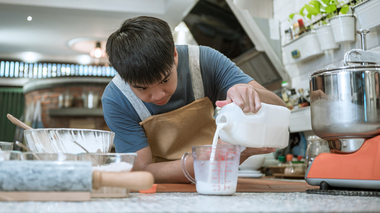 man measuring milk