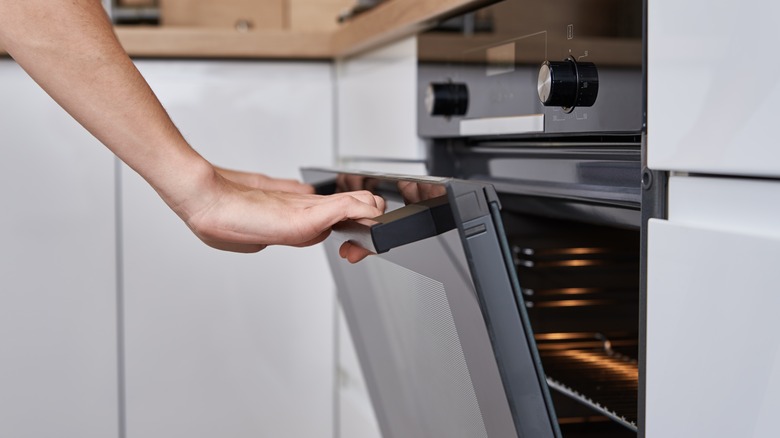 woman opening oven door