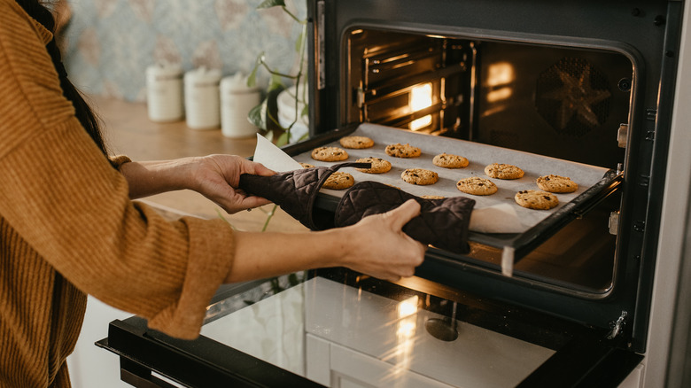 woman taking cookies out of the oven