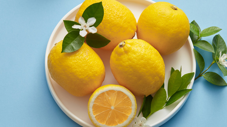 lemons on white plate with floral garnish