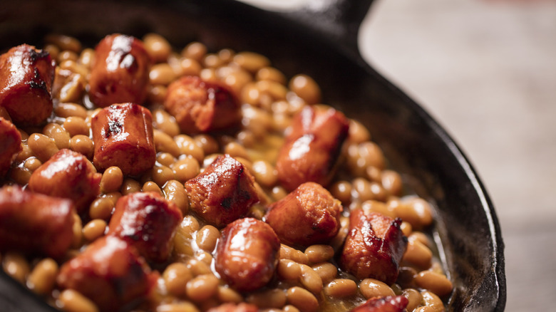 hot dogs and baked beans in cast iron skillet