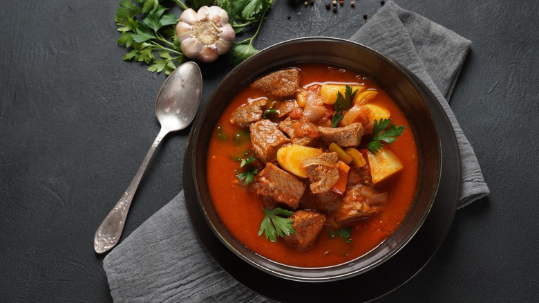 Beef stew with vegetables black bowl