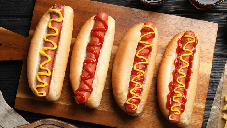 four hot dogs on a serving board