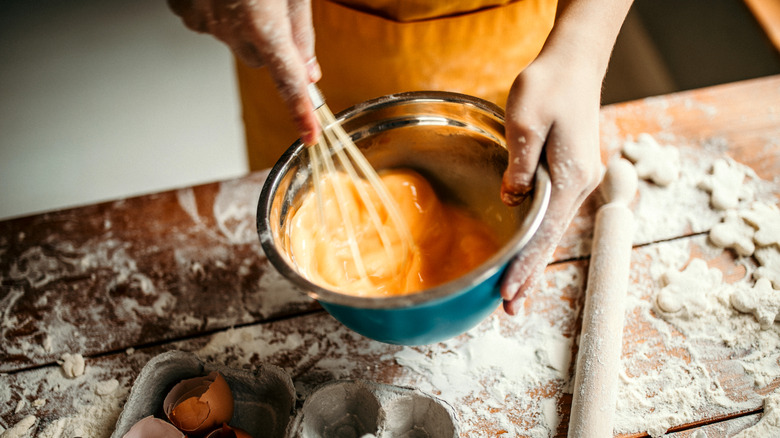 chef whisking eggs in bowl