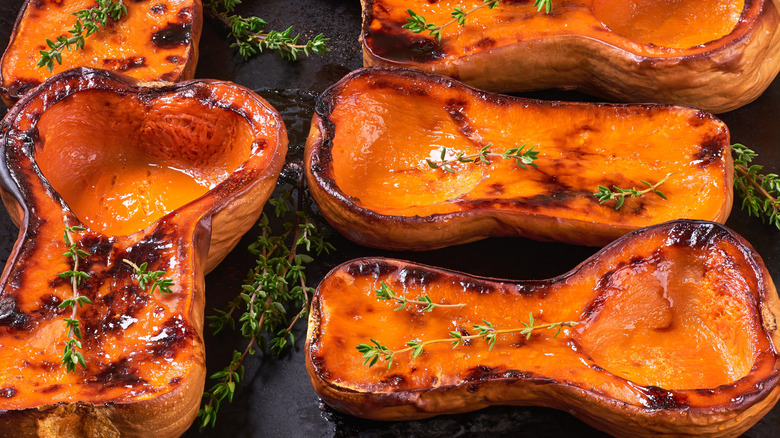 Grilled butternut squash halves with thyme stalks