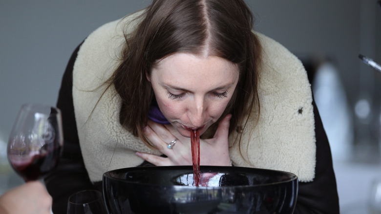 Woman spitting wine