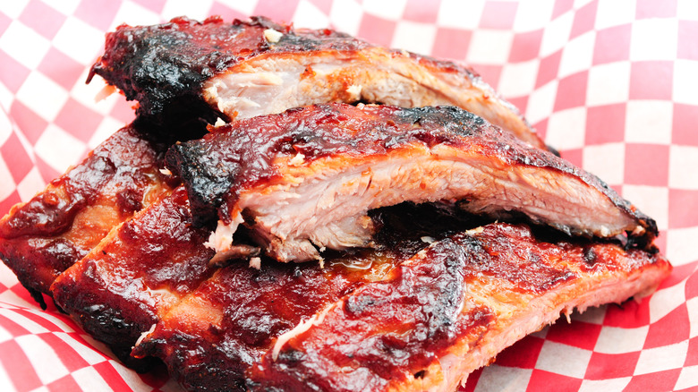 cut barbecue ribs covered in sauce ready to eat