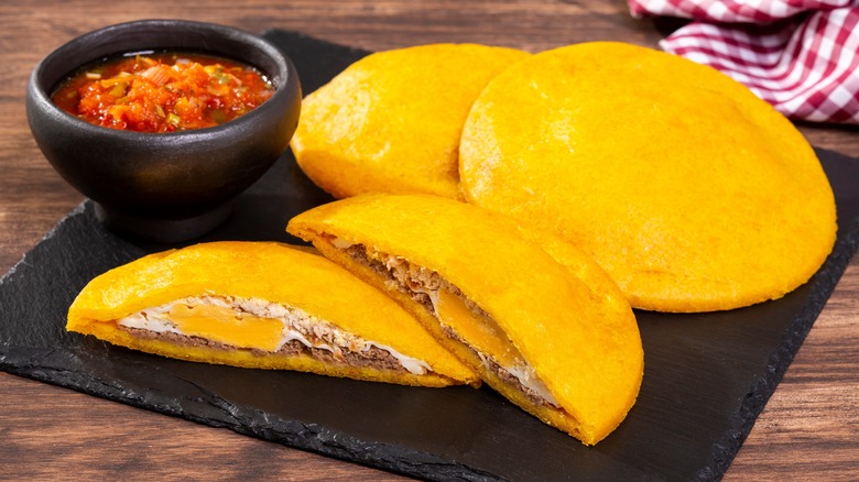 arepas on a plate with eggs and other fillings