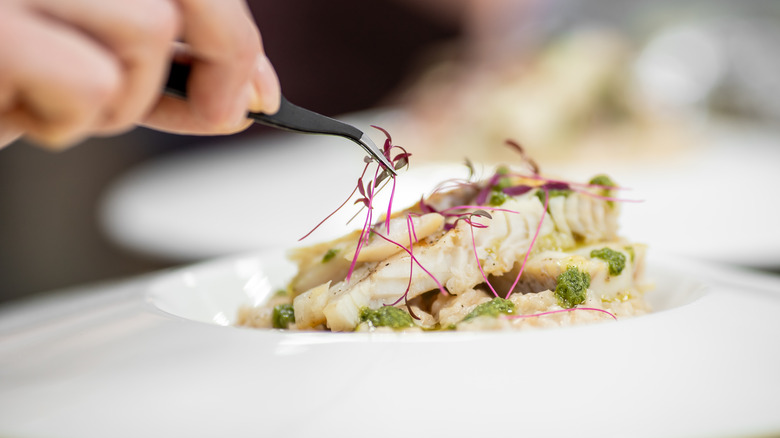 Chef plating dish with tweezers