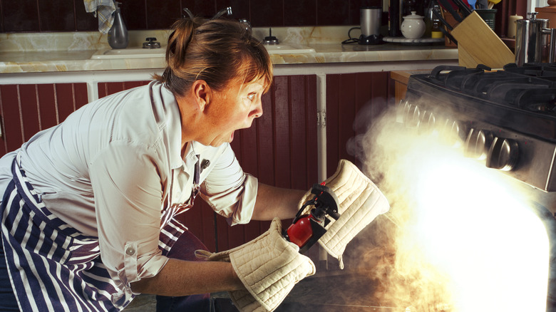 woman trying to put out oven fire