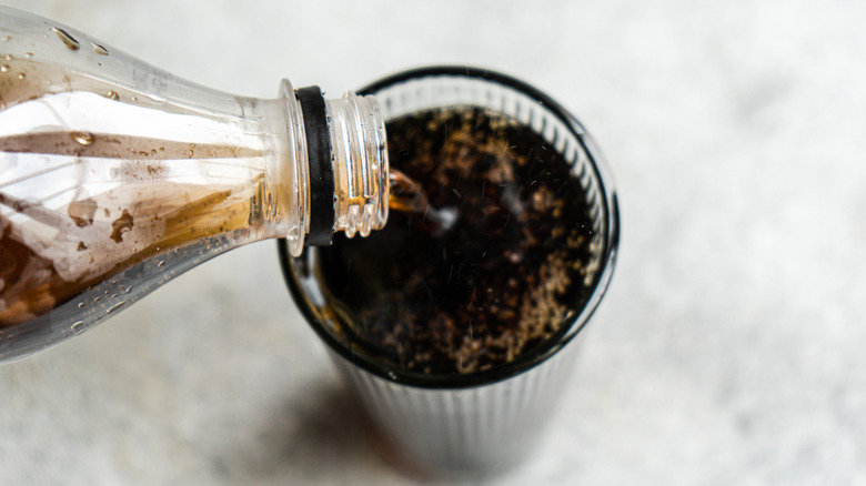 Pouring cola into a glass.