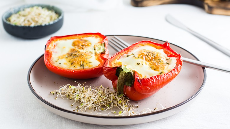 Eggs baked in red bell pepper on a plate with bean sprouts