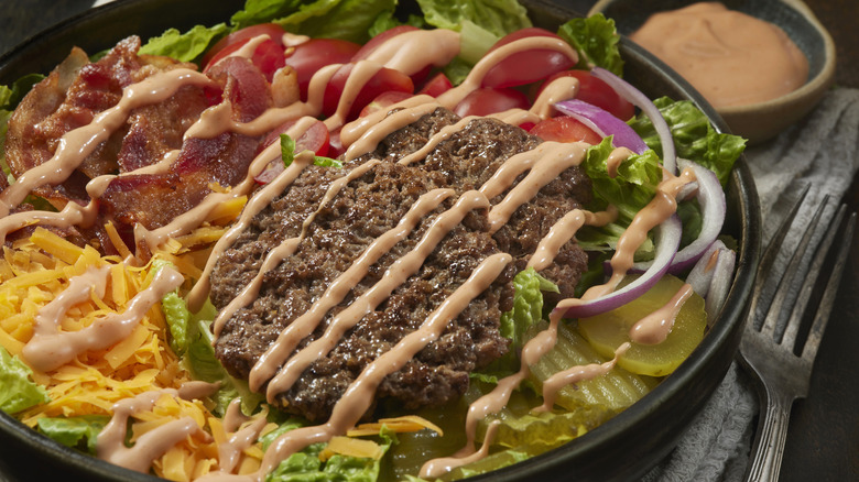 cheeseburger ingredients on bed of lettuce