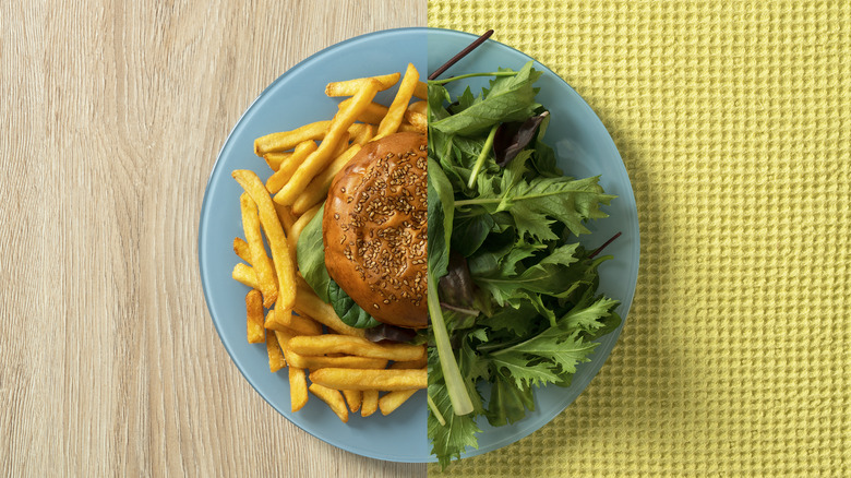 plate divided into halves of a salad and burger