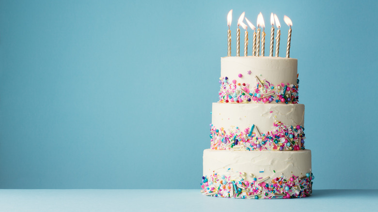 White three-layer cake with candles 