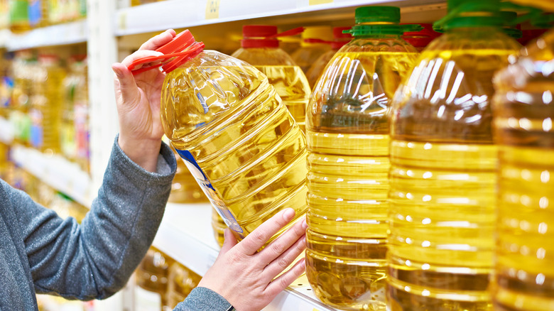 Person grabbing jug of oil