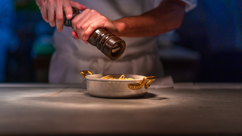 Person grinding black pepper