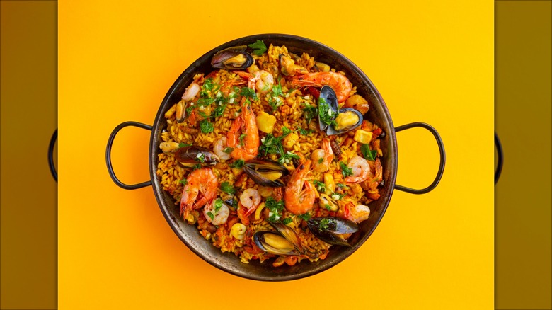 Paella dish against yellow background