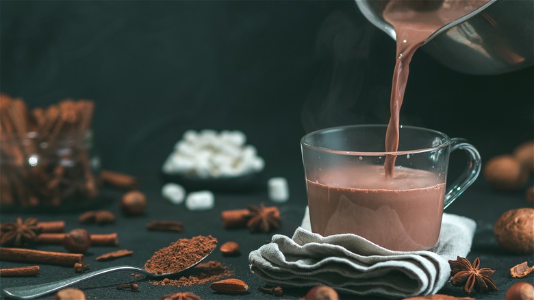 Hot chocolate poured into glass mug 