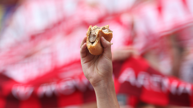 Person holding up a half-eaten bratwurst