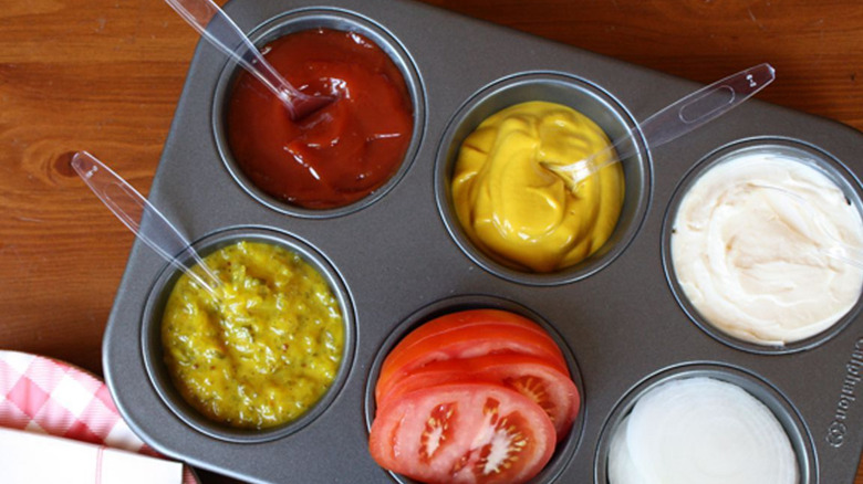 Muffin tray filled with condiments