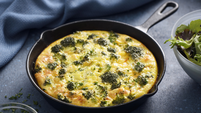 a breakfast frittata in an iron skillet on a dark background