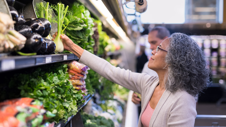 Person buying vegetables at supermarket