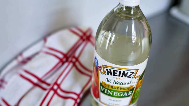 bottle of vinegar next to a tea towel