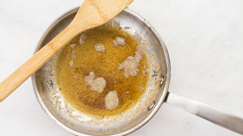 Brown butter in pan with wooden spatula