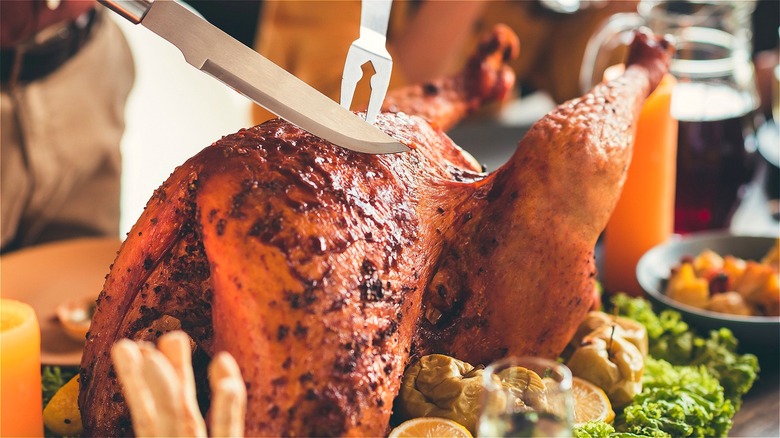 Fork and knife against roasted turkey 