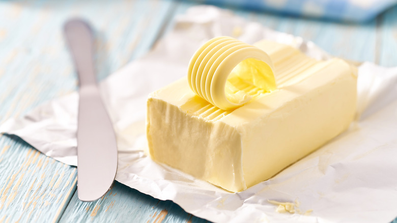 A package of butter beside a butter knife