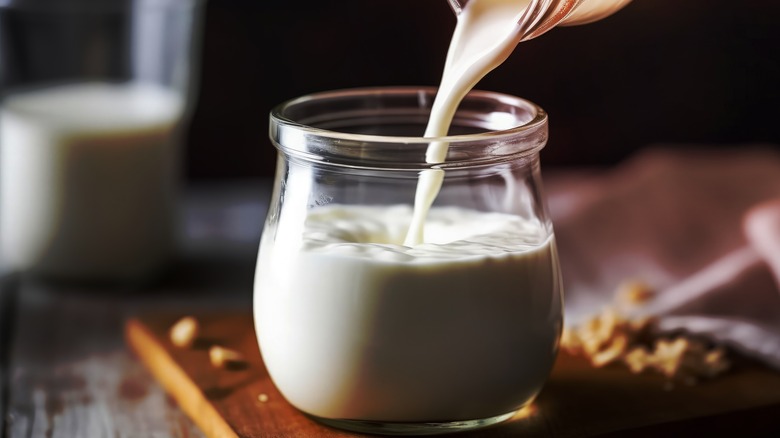 Pouring buttermilk into a glass container