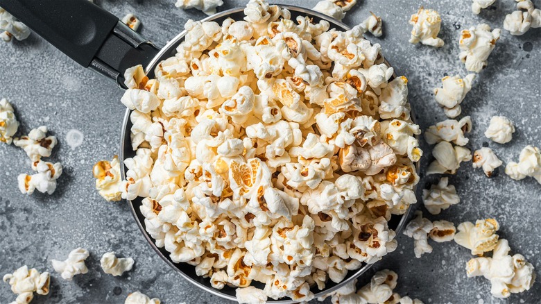 popcorn overflowing out of pot over gravel counter