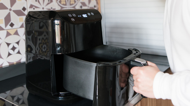 man grabbing air fryer basket