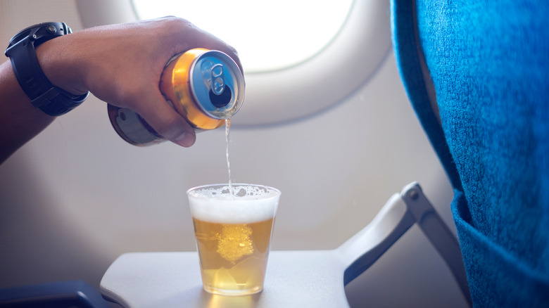 Pouring beer can on plane 