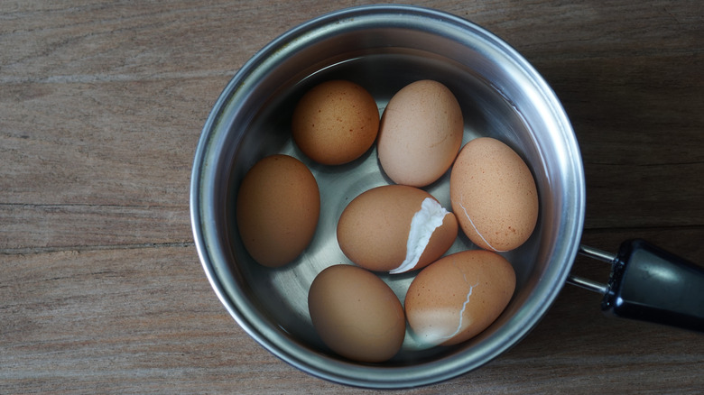 pan of cracked boiled eggs 