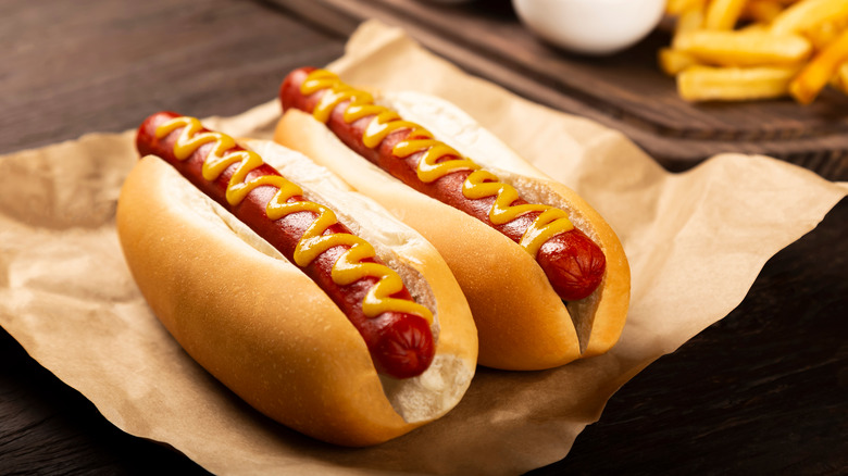 Pair of hot dogs on brown parchment paper