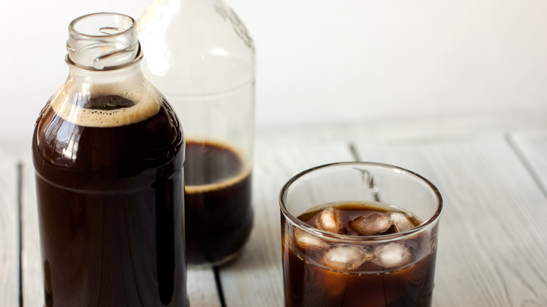 Bottles and cup of cold brew coffee 