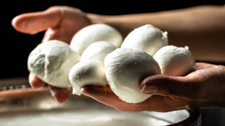 hands holding balls of mozzarella