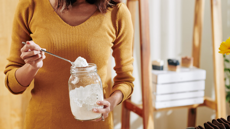 woman spooning baking powder jar