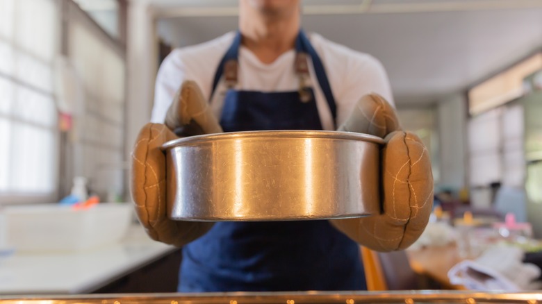 Person taking a cake out of the oven