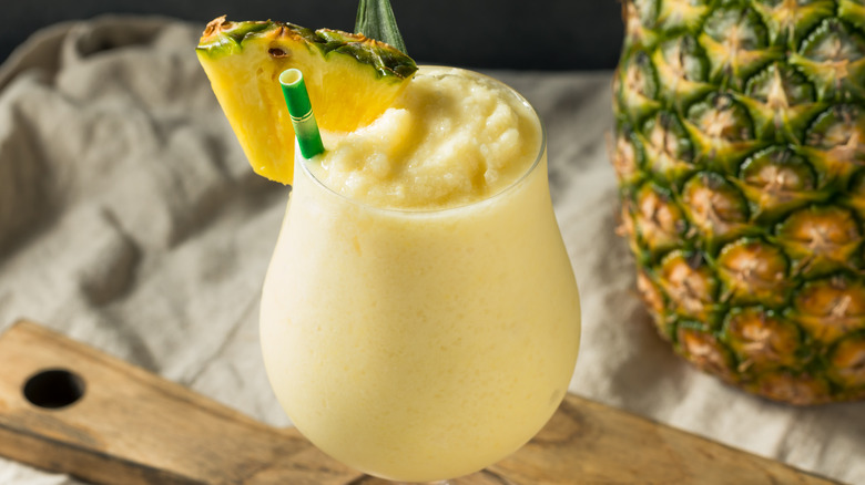 Pina colada on a board next to a pineapple