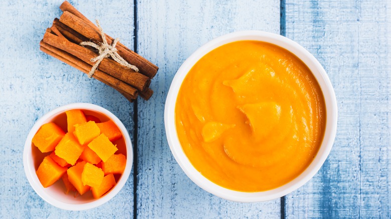 Bowl of pumpkin puree with cinnamon sticks