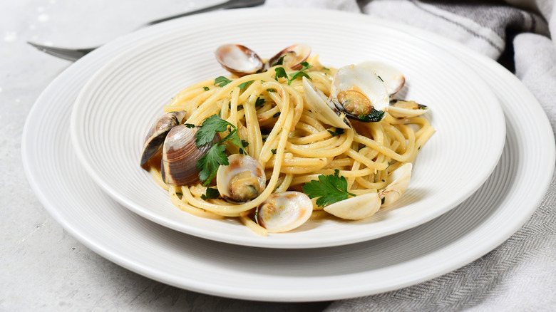 Clam pasta with parsley in white bowl