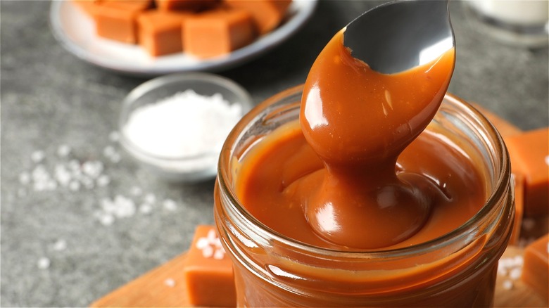 Spoon in jar of caramel 