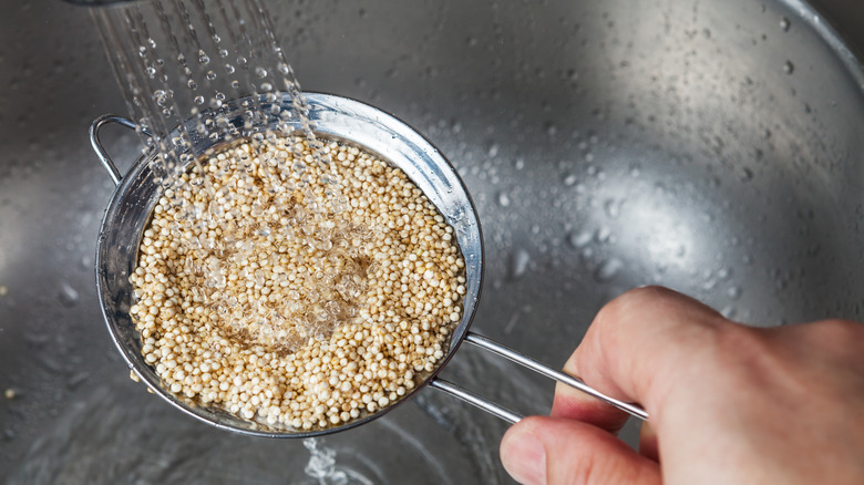 Quinoa being rinsed in strainer